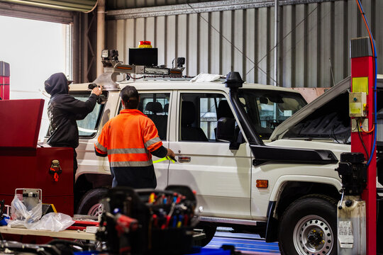 workmen in workshop adding reflective tape to complete fitout of mining fleet vehicle