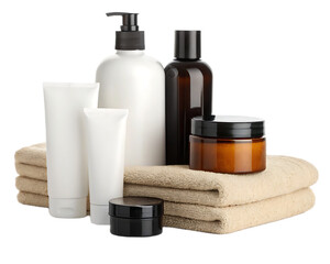 Assortment of cosmetic products on folded towels featuring bottles tubes and jars in a studio shot