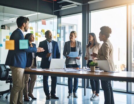 Diverse team brainstorming in a modern coworking office with sticky notes and laptops.