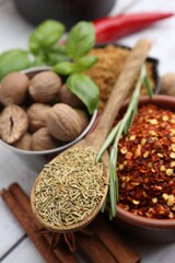 Different aromatic spices on white wooden table, closeup