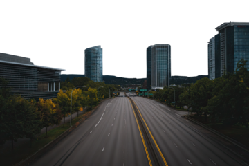 Empty highway between modern city buildings at dusk