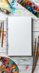 Blank sketchbook surrounded by art supplies