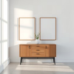 Wooden sideboard with two blank picture frames and a vase with branches on a white wall