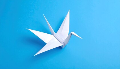 A meticulously crafted origami crane, poised against a vibrant blue backdrop, displays intricate folds and delicate artistry.