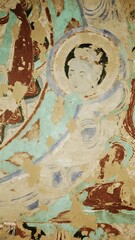 Fototapeta premium Ancient Mural Depicting a Serene Figure with Halo, Set Against a Turquoise Background