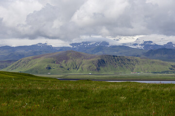 Obraz premium Green grass field with mountain view.