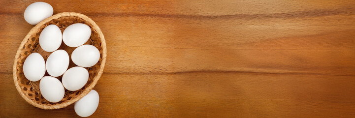 Basket of Eggs on Wooden Surface Wide Banner with Copy Space