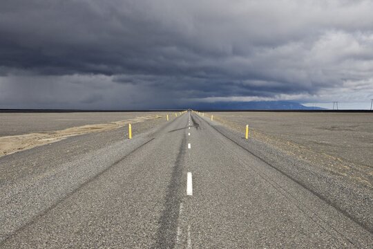 Thunderclouds forming over a highway, Skei&eth;ararsandur glacial outwash plain, southern coast of Iceland, Atlantic Ocean