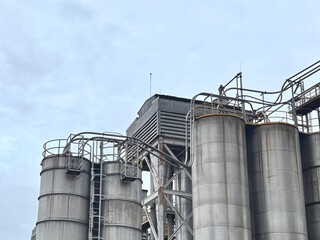 A close-up of a dirty, corroded water pump and motor in an industrial building. The image captures the heavy-duty machinery used for fluid circulation, with a focus on its worn and aged condition, cov
