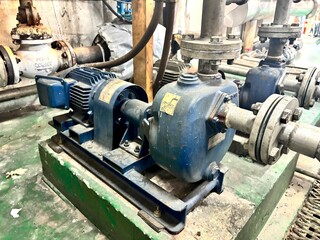 An industrial pump and electric motor system in a factory. This image captures the essential heavy machinery used in industrial processes, such as fluid transfer and chemical manufacturing, highlighti