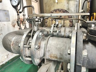 old industrial machine. Piping and flanges in an industrial setting, with a focus on the mechanical...