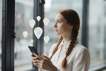 Woman with braided auburn hair looking out window with phone