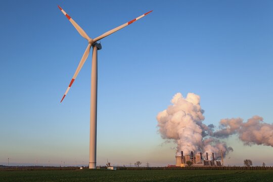 Wind turbine in the evening light, back RWE Power AG, Neurath power plant, lignite power plant, steaming chimneys, coal exit, near Neurath, Rhenish lignite mining area, North Rhine-Westphalia, Germany