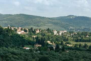 Fototapeta premium Tuscan dreamy landscape with rural houses and vineyards. Green hills with vineyards and cypress trees