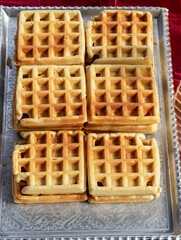 Freshly baked waffle pastry on a plate sold outside on a market
