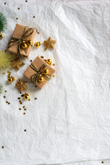 Gold Christmas theme decorations on paper texture background,  Christmas tree, gold presents box, decorative gold stars and Christmas ball. 