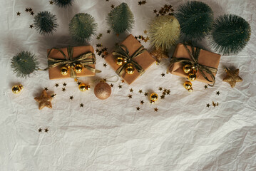 Gold Christmas theme decorations on paper texture background,  Christmas tree, gold presents box, decorative gold stars and Christmas ball. 