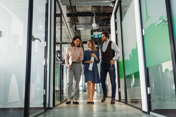 Group of coworkers walking down the office corridor.