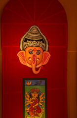 Obraz premium Handmade colorful face mask souvenir hanging on plain black background. Selective focus on object.