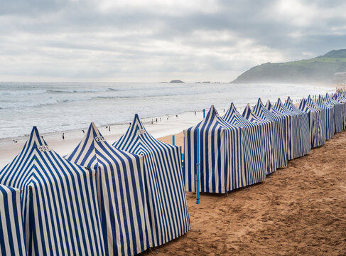Striped tents along Zarautz beach shoreline