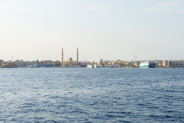 Coastal cityscape with mosque and boats