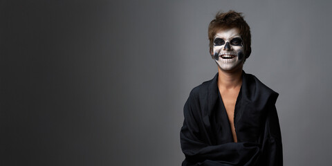 Fototapeta premium Smiling Child in Skeleton Makeup Wide Banner with Copy Space