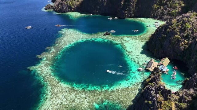 Aerial perspective of the stunning Twin Lagoon, with turquoise waters and a few houses in Coron, Philippines