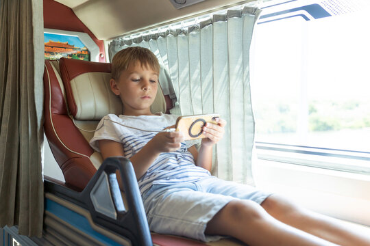 Child, boy, traveling in a sleeper bus in Vietnam, bed seat in the bus, kid on vacation summer