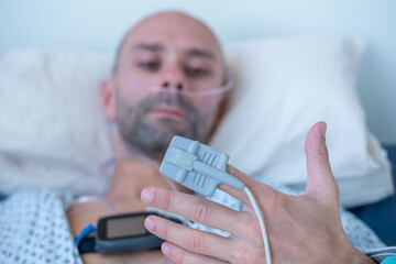 Patient finger with Pulse oximeter monitoring oxygen saturation level monitoring, finger sensor medical device, SpO2 measurement, EMS stimulator, healthcare technology, medical examination equipment