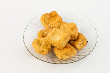 Crispy fried tofu cubes served on elegant glass plate, ready for delicious vegan meals and healthy recipes