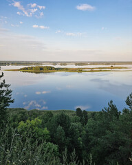 Obraz premium Dnipro river at sunset - aerial view from a hill on the right bank near Vytachiv. Wide flood plain with islands reflecting dramatic sky at sunset.