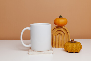 Mockup white coffee mug on wooden coaster with pumpkins. Minimal mockup cup for autumn design, logo or print