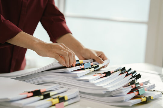 A cluttered office desk filled with paperwork, documents, files, and reports, symbolizing heavy workload, financial management, research, business tasks, corporate responsibilities, stress, and organi