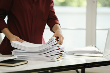 A cluttered office desk filled with paperwork, documents, files, and reports, symbolizing heavy workload, financial management, research, business tasks, corporate responsibilities, stress, and organi