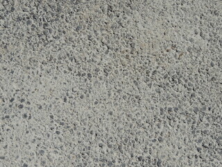 frozen concrete with air bubbles in texture close-up, background texture, pimply dry light gray mortar as empty copy space