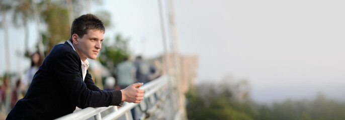 Thoughtful Man on Balcony Wide Banner with Copy Space