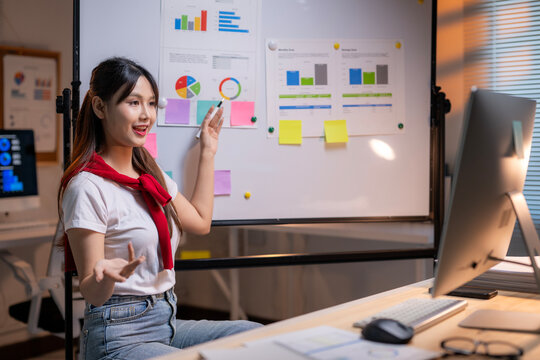 A woman is giving a presentation in front of a white board