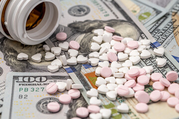 Dollar bill and a set of medicine pills. Rising costs of medical care. Reliefs for buying medicine.Pills in capsules scattered on US dollars currency.Concept of health care in USA.