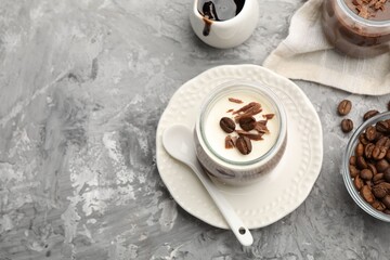 Delicious panna cotta with chocolate chunks and coffee beans served on grey textured table, above view. Space for text