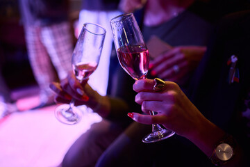 Elegant Hand Holding a Glass of Ros Champagne at an Event