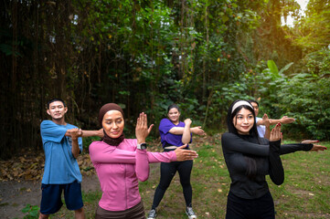 Obraz premium Indonesian southeast asian people in a sporty outfit practice exercise together in a public park outdoors. Concept of a Healthy active lifestyle