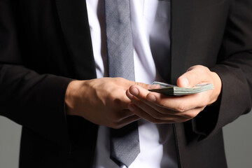 Man with dollar bills on grey background, closeup