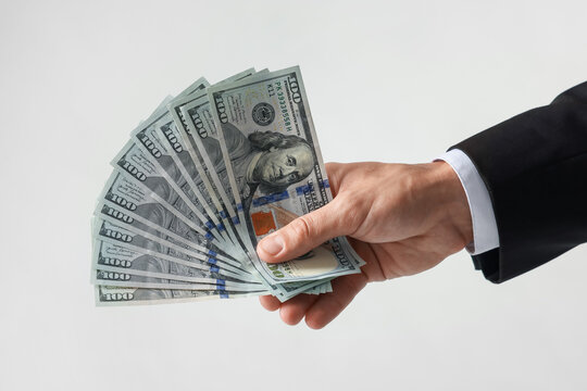 Man with dollar bills on light background, closeup