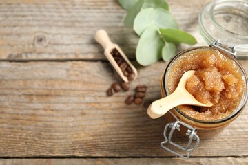 Natural body scrub and coffee beans on wooden table, above view. Space for text