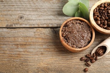 Natural body scrub and coffee beans on wooden table, flat lay. Space for text