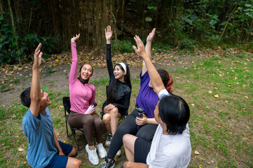 Indonesian southeast asian people in a sporty outfit, stacking hands together before practice exercise in a public park outdoors. Concept of a Healthy active lifestyle