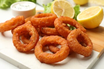 Fried squid rings served with sauce on table, closeup