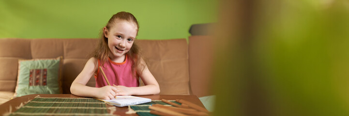 Smiling Child Drawing at Table with Copy Space, Wide Banner