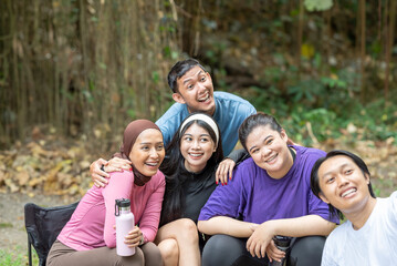 Indonesian southeast asian people in a sporty outfit taking a selfie together after practice exercise in a public park outdoors. Concept of a Healthy active lifestyle