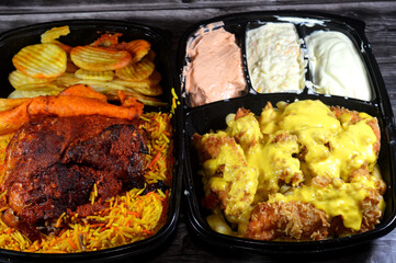 chicken meals of Crispy fried chicken and French fries with melted Cheddar cheese sauce, and Aleppo Arabic Syrian cuisine of machine grilled barbecued chicken with colorful Basmati rice